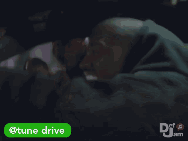 a man sitting in a car with a tune drive button