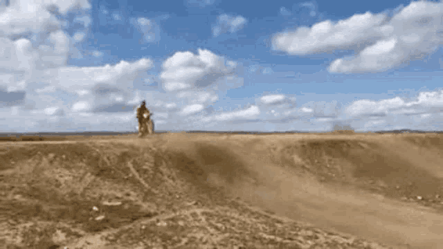 a person is riding a dirt bike on a dirt track