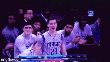 a basketball player with the number 23 on his jersey is surrounded by his teammates
