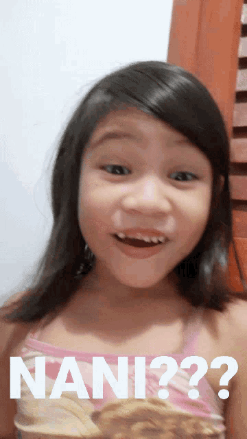 a little girl is smiling with the words nani on her face