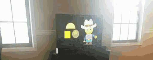 a drawing of a cowboy is on a black board in a room with two windows .