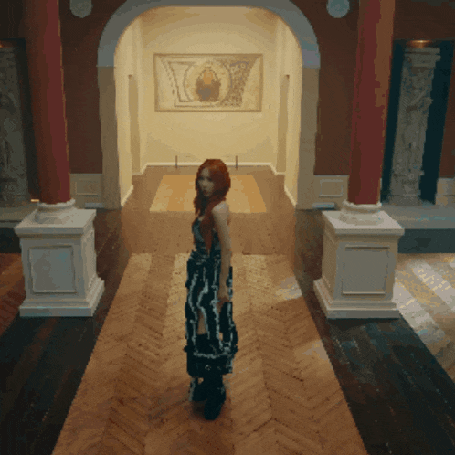 a woman in a black and white dress stands in a hallway in front of a painting