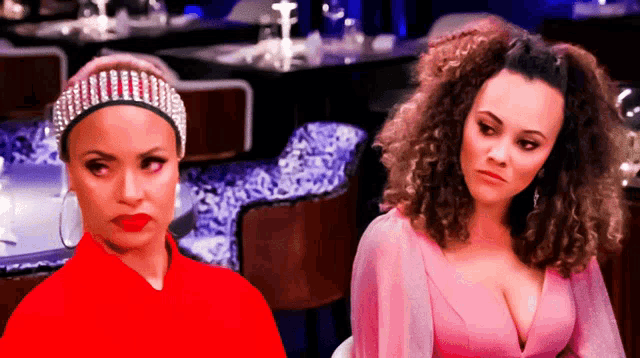 a woman wearing a headband with rhinestones sits next to another woman