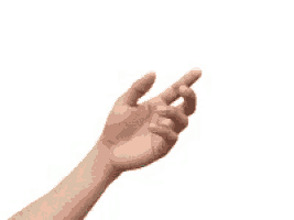 a person 's hand is reaching out towards a green butterfly flying in the air .