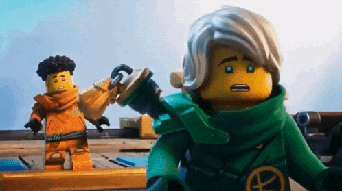 a couple of lego figures standing next to each other .