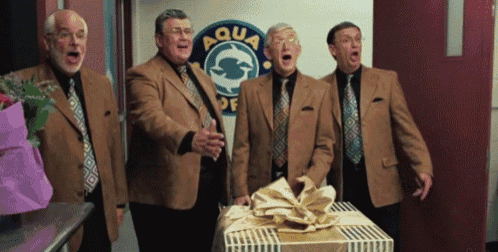 four men are singing in front of a sign that says aqua