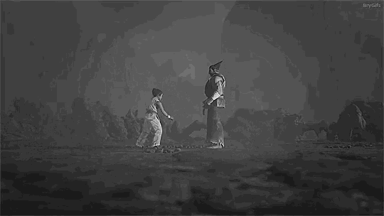 a black and white photo of a man and a woman fighting each other in a video game .