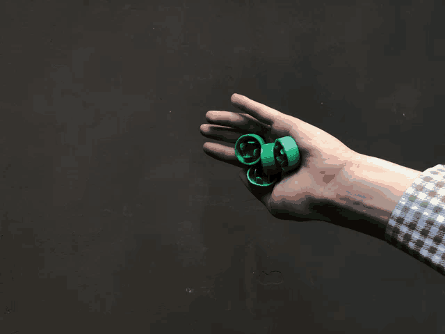 a person holding three green wheels in their left hand