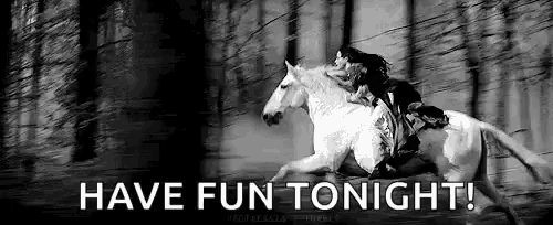 a woman is riding on the back of a white horse in a forest .