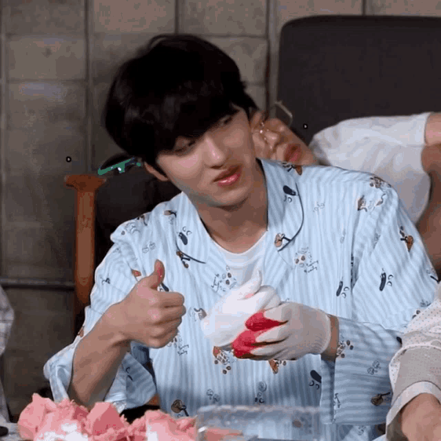 a boy in a pajama shirt is giving a thumbs up sign