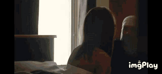 a man and a woman are laying on a bed in a room .