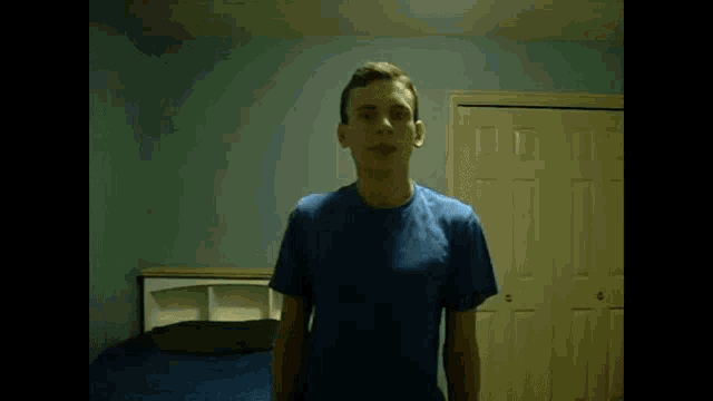 a young man in a blue shirt is standing in front of a door and says hey youtube its me lugia
