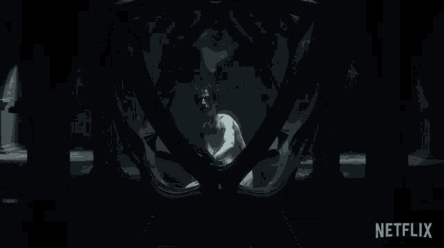 a naked man in a dark room with a netflix logo behind him