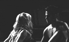 a black and white photo of a man and woman looking at each other