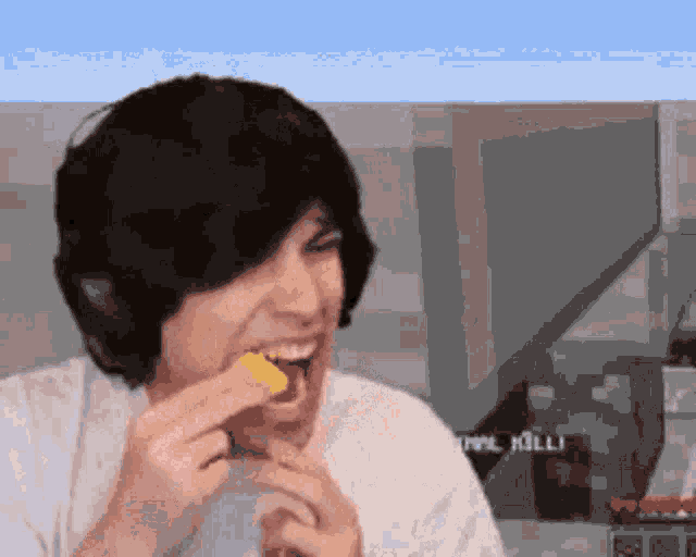 a man wearing headphones is eating a piece of food while wearing a white shirt .