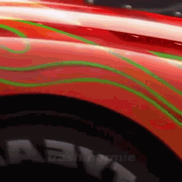 a close up of a red car with green lines painted on it