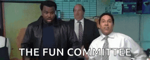 a group of men in suits and ties are standing in a room with the words `` the fun committee '' .