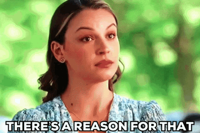 a woman in a blue dress is standing in front of a green background and says `` there 's a reason for that '' .