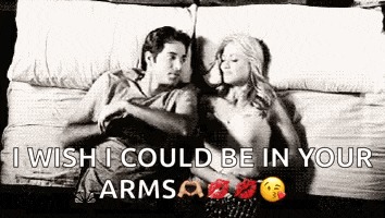 a man and a woman are laying on a bed and hugging .