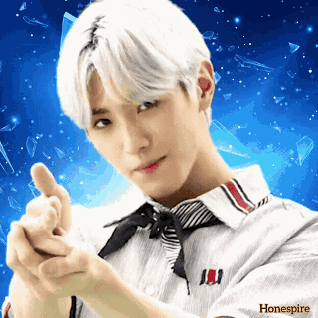 a boy with white hair is making a heart shape with his fingers