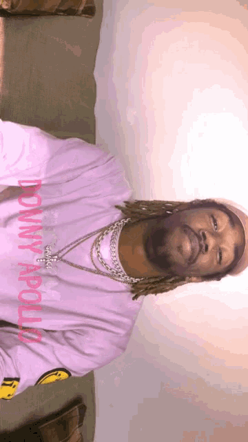 a man wearing a pink shirt with the word dominy apollo on it