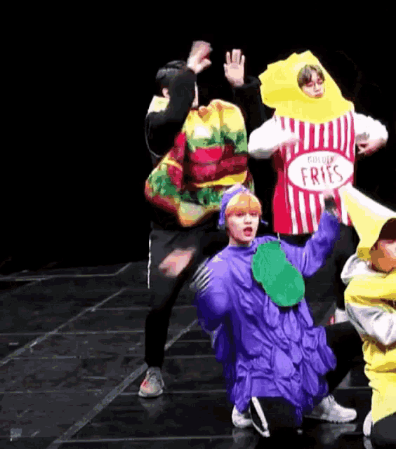 a group of people are dancing on a stage while wearing costumes .