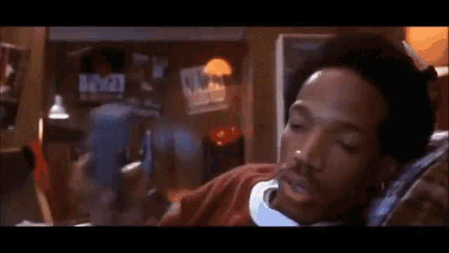 a man is laying on a couch talking on a cell phone and the word yo is on the bottom