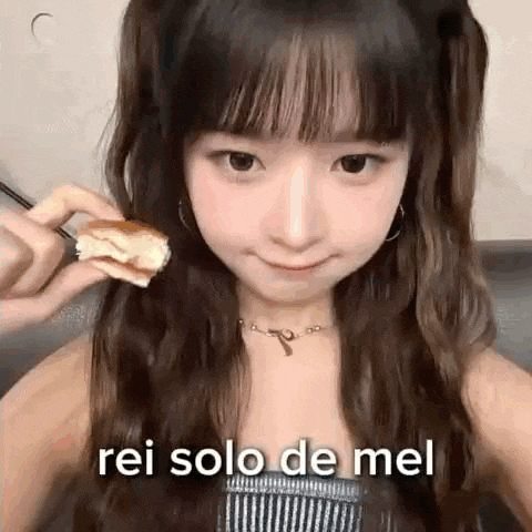 a young girl is holding a piece of cake in her hand and eating it .