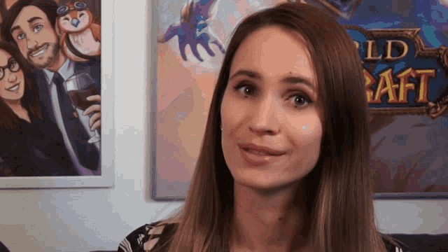 a woman stands in front of a world of warcraft painting