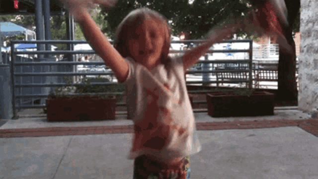 a little girl dancing with her arms outstretched