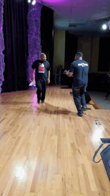a man wearing a t-shirt that says ' i love you ' on it walks across a wooden floor