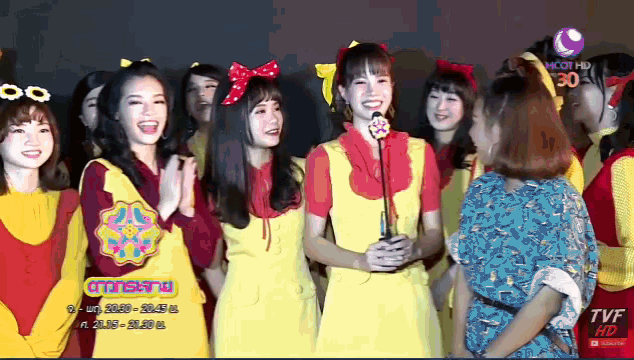 a group of girls are standing in front of a tvf hd sign