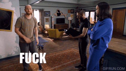 a group of men are standing in a living room and the word fuck is on the floor in front of them