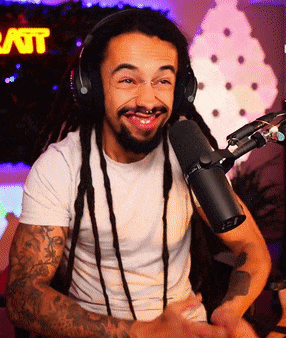 a man wearing headphones is smiling in front of a microphone with a sign in the background that says latt