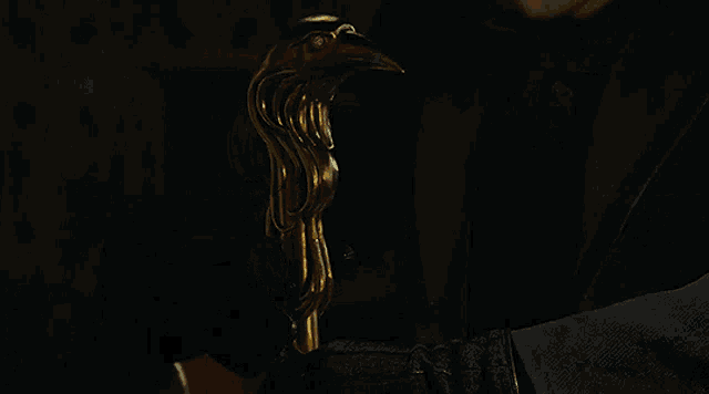 a man in a suit and tie is holding a statue of a bird