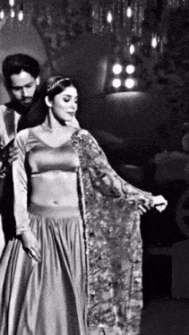 a black and white photo of a woman dancing with a man
