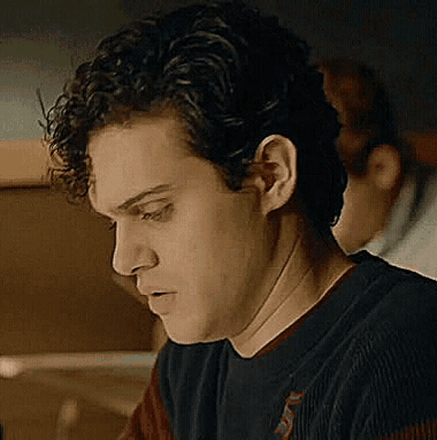 a close up of a young man 's face with curly hair .