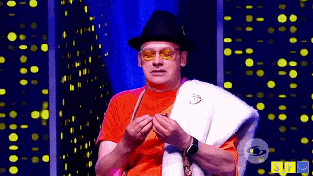 a man wearing a hat and sunglasses is sitting in front of a screen that says ' rf ' on it