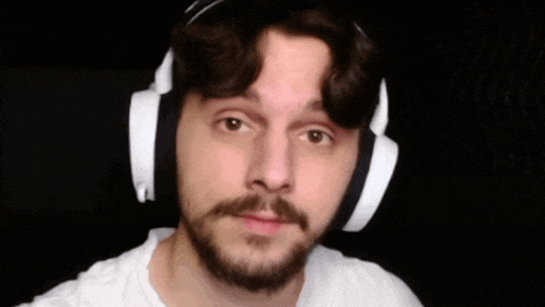 a man with a beard and mustache wearing headphones .