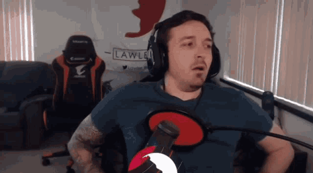 a man wearing headphones stands in front of a sign that says lawler