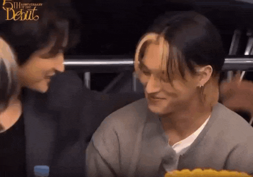a man and a woman are sitting next to each other and talking to each other .