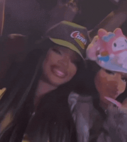 a woman wearing a hat and sunglasses is taking a selfie .