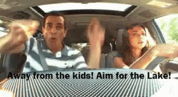 a man and a woman are driving a car with the words " away from the kids aim for the lake " on the bottom