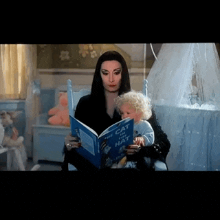 a woman is reading a book to a baby in a nursery