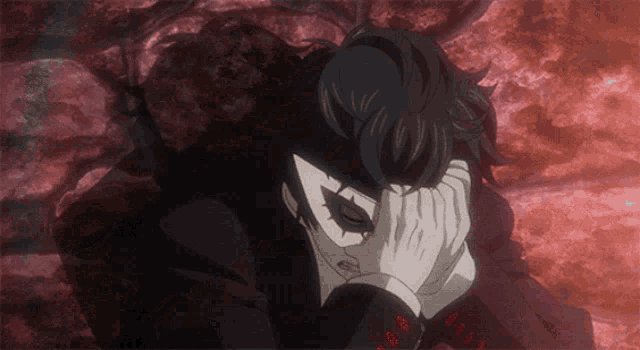 a man with a joker mask covering his face with his hand