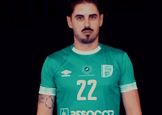 a man wearing a green shirt with the number 22 on the front