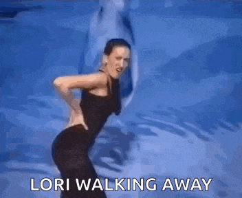 a woman is dancing in front of a dolphin and the words `` lori walking away '' .