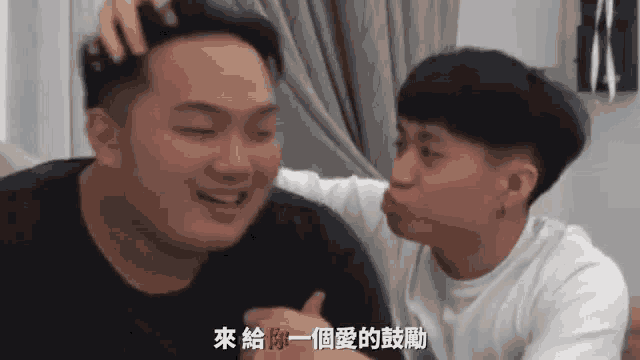 two young men are kissing each other on the cheek in a room .
