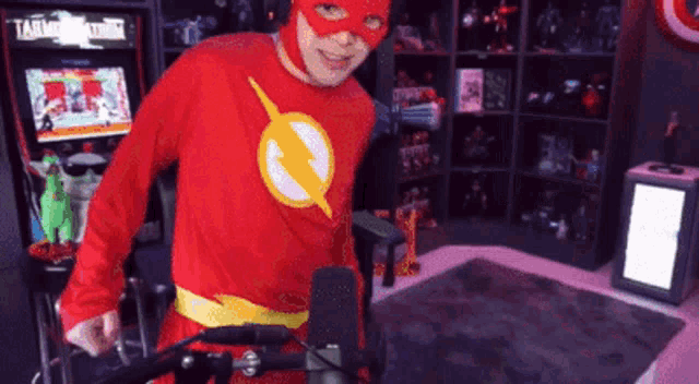 a person dressed in a flash costume stands in front of a microphone