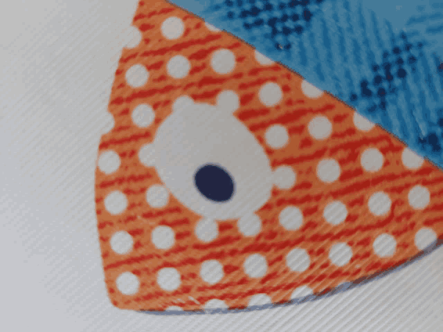 a piece of fabric with polka dots and a bear face